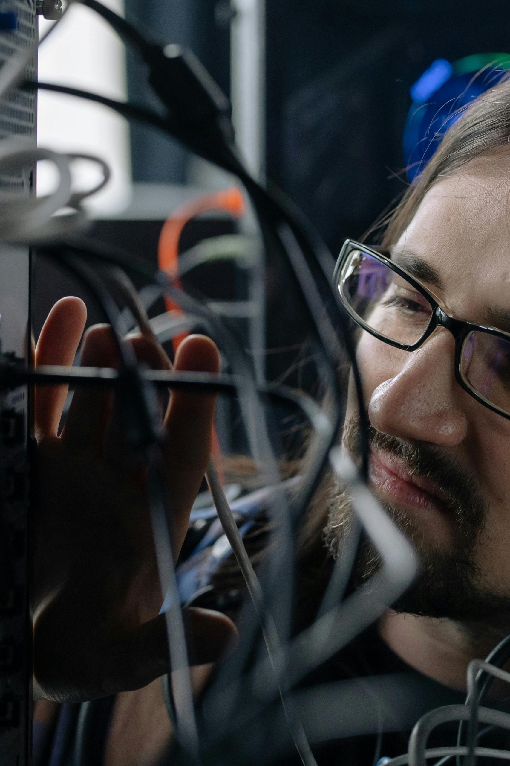 IT network engineer inspecting server room cabling and fiber optic deployment