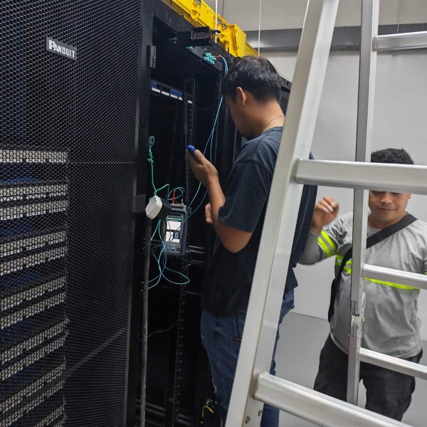 SDSI technicians installing network cabling inside a server rack enclosure