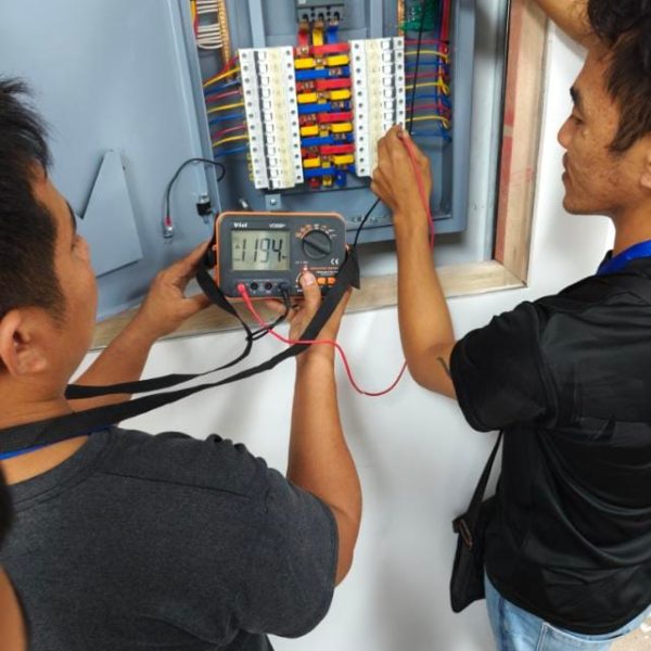 SDSI engineers using a multimeter to test electrical power distribution panel circuits